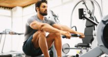 Une homme sur un rameur dans une salle de musculation